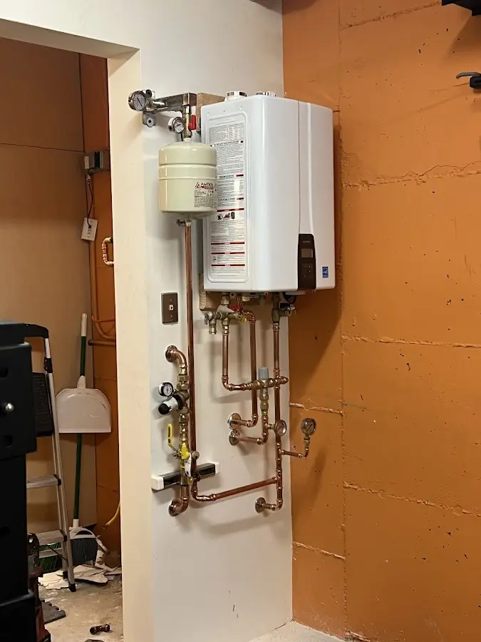 Plumbing technician inspecting water heater connections in Fort Mohave